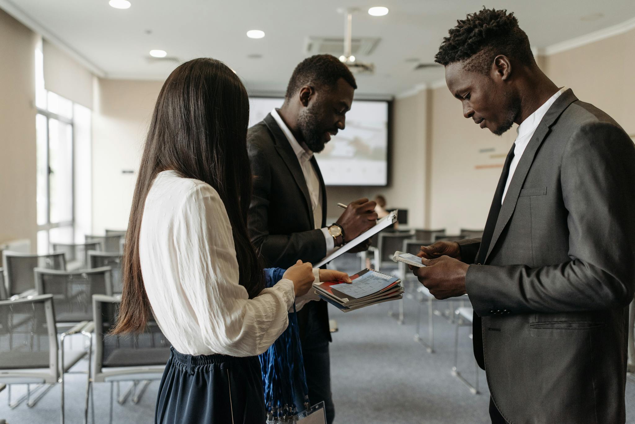 Three business professionals engaged in discussion at a conference room, exchanging ideas.